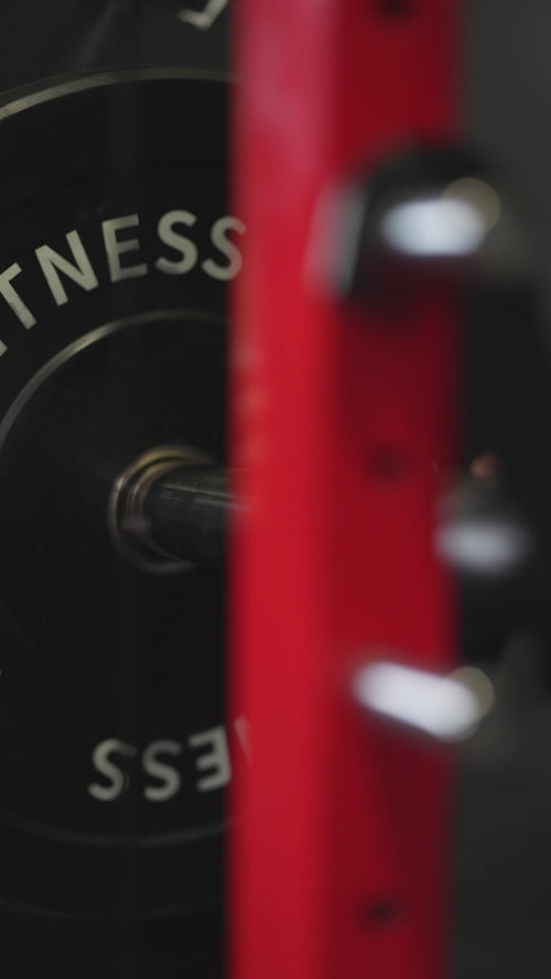 Close-up of plates loading onto the GTA Fitness Smith Machine and its cable pulley